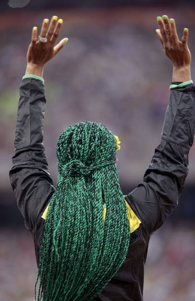 Una delle pi fotografate ai mondiali di atletica di Pechino. L&#39;esultanza di Shelly Ann Fraser dopo la vittoria dei 100 metri. L&#39;atleta si  presentata con i capelli raccolti in lunghe treccine verdi e una corona di margherite gialle: i colori della sua Giamaica (Lapresse)